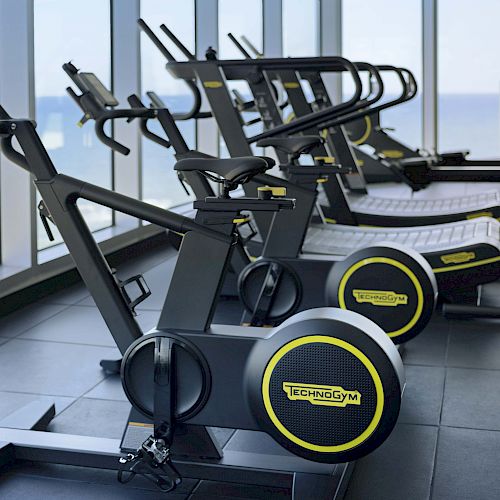 A line of stationary bikes and treadmills with 