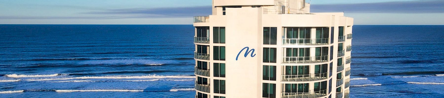 A beachfront high-rise building with a blue 