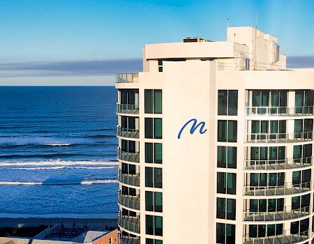 A beachfront high-rise building with a blue 