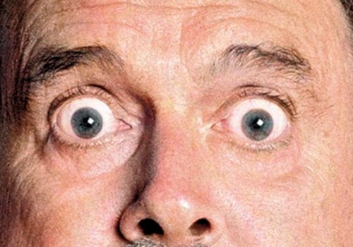 A close-up of a person's wide-open eyes, conveying surprise or shock, with a visible nose and eyebrows.