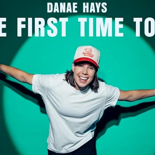 A person with outstretched arms smiles under the text "Danae Hays The First Time Tour" with a green background.