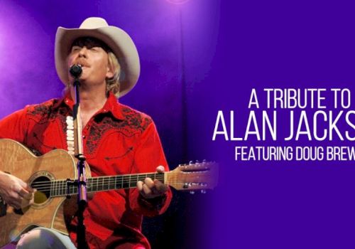 A performer in a white hat and red shirt plays an acoustic guitar and sings on stage, with &ldquo;A Tribute to Alan Jackson&rdquo; text overlay.