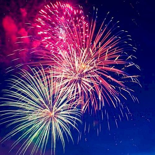 The image shows colorful fireworks exploding in the night sky, creating vibrant patterns of light against a dark backdrop.