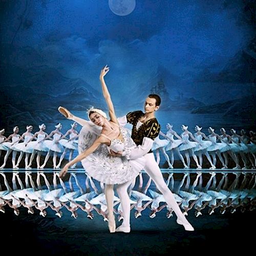 A ballet performance with a pair in the foreground and multiple dancers in a line behind, set against a moonlit blue background.