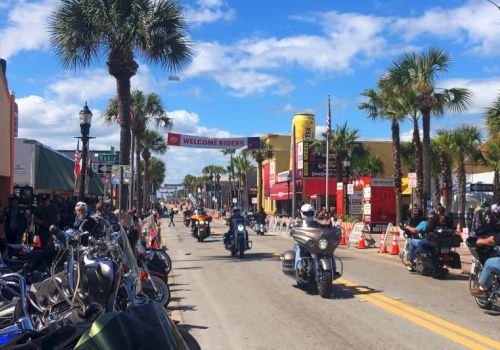 A sunny street lined with palm trees and parked motorcycles for a &ldquo;Welcome Riders&rdquo; rally.