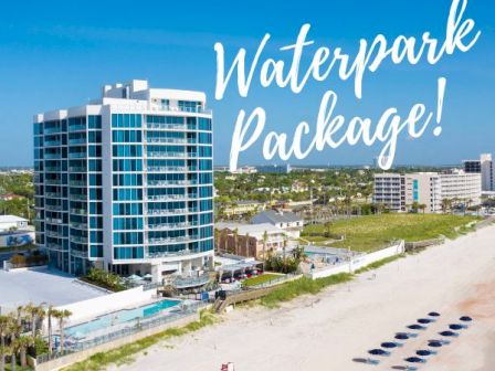 The image shows a beachfront hotel with the text "Waterpark Package!" written on it. There are buildings, the beach, and ocean in the background.