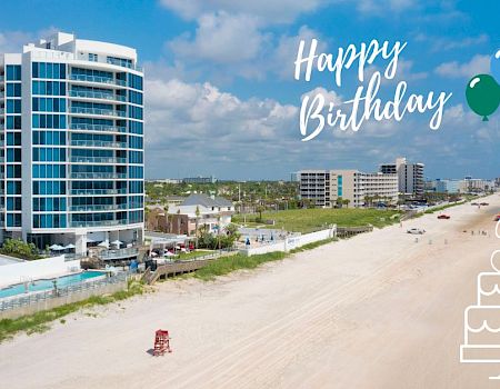 A beachfront scene with buildings, a sandy shore, and ocean waves. "Happy Birthday" text, balloons, and cake graphic with number 3.