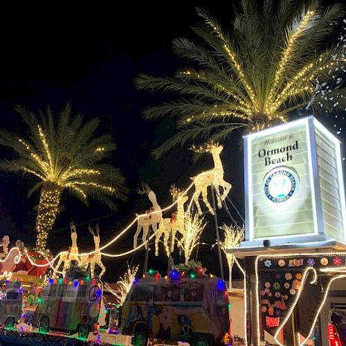 A festive holiday display with illuminated reindeer and sleigh, palm trees, and a lit sign for Universal Parks.