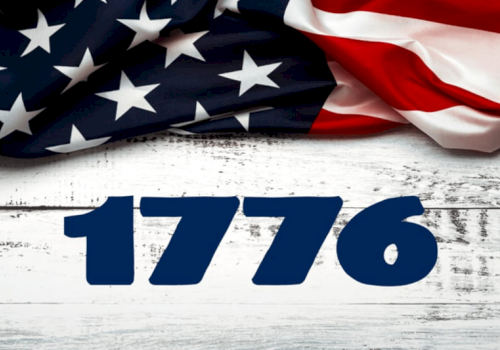 Patriotic scene with a waving American flag and bold blue &ldquo;1776&rdquo; on a white wooden background.
